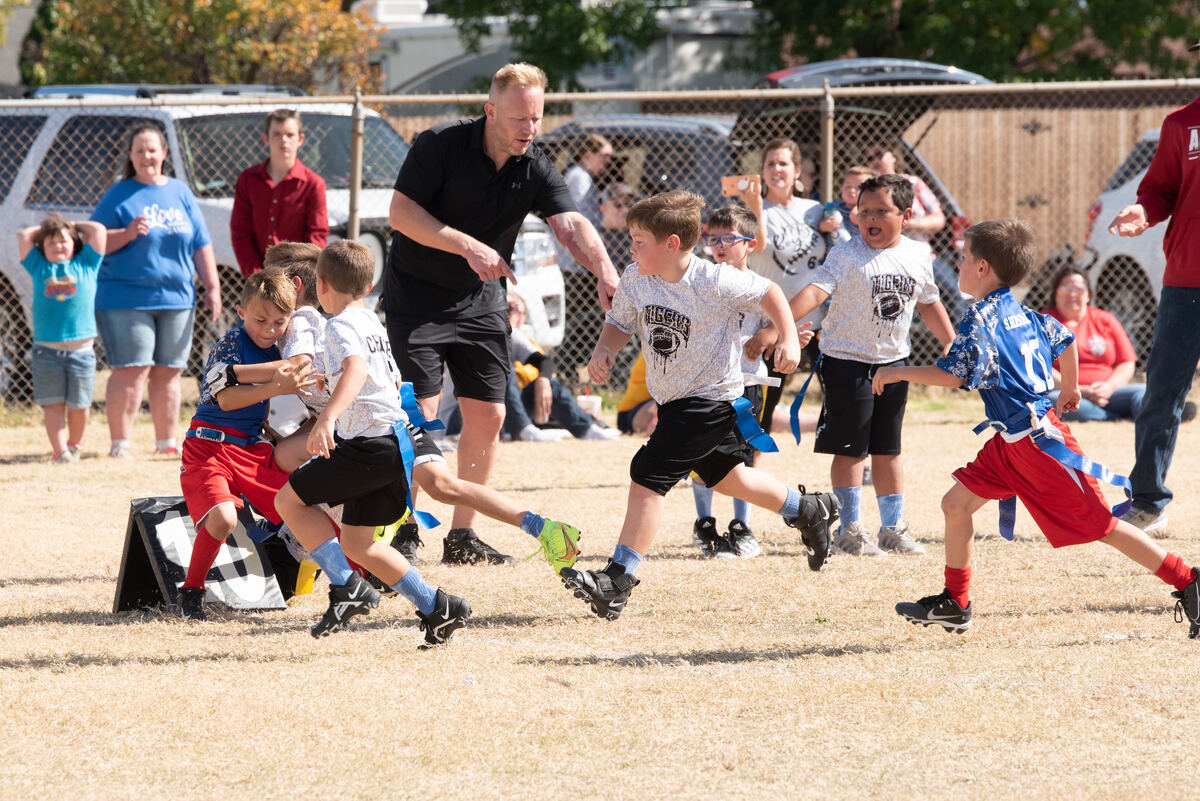 Flag football players chasing the ball carrier