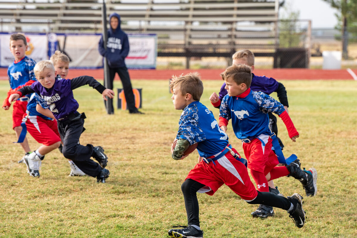 Flag football ball carrier breaking away from defenders